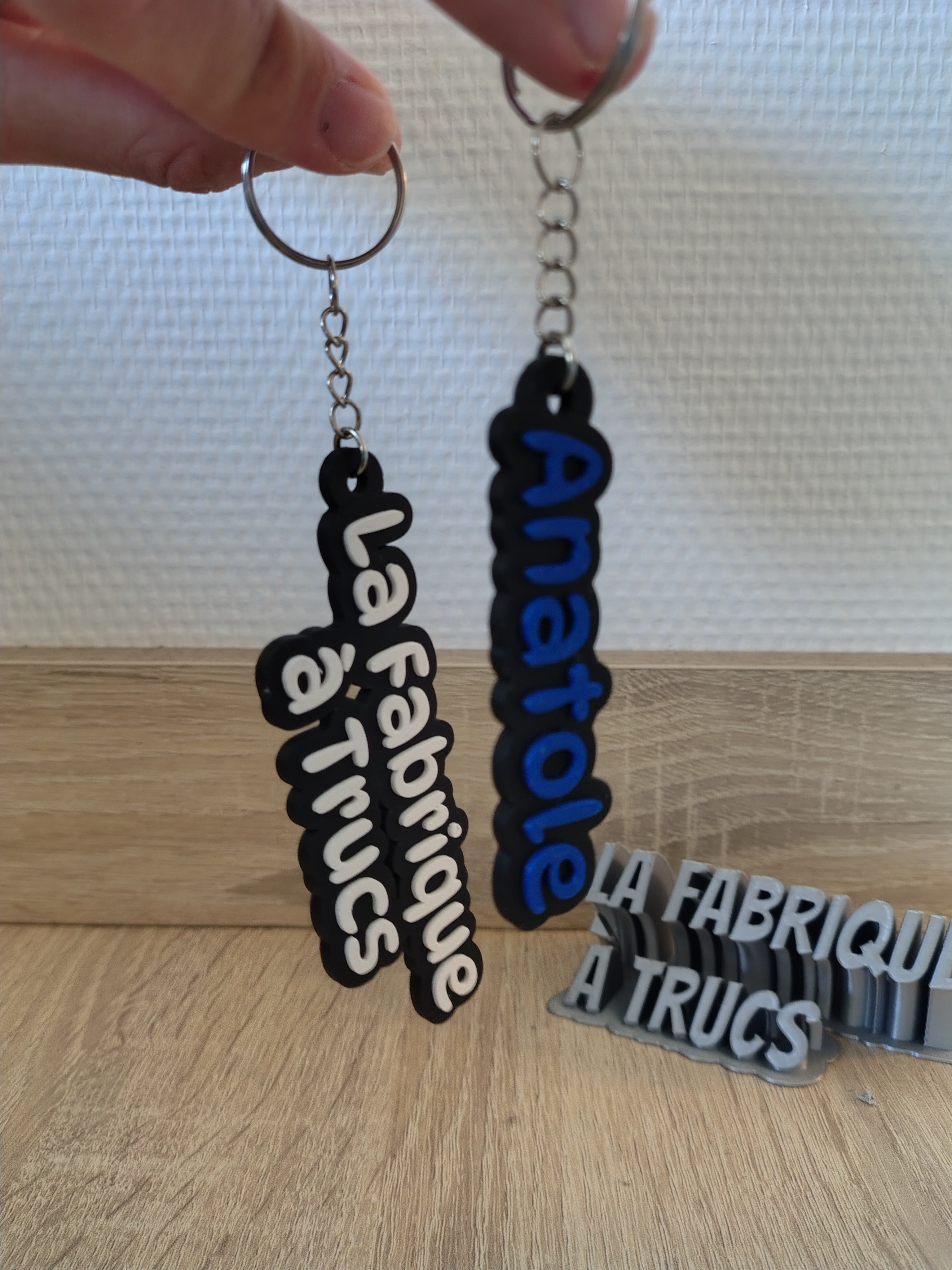 Porte-clé personnalisé en impression 3D avec prénom en relief noir et couleur contrastée.